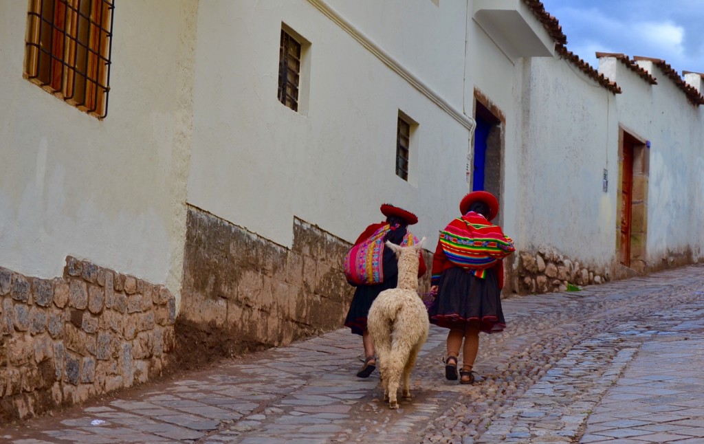 Peruvian women and an alpaca walking in Cusco, Peru