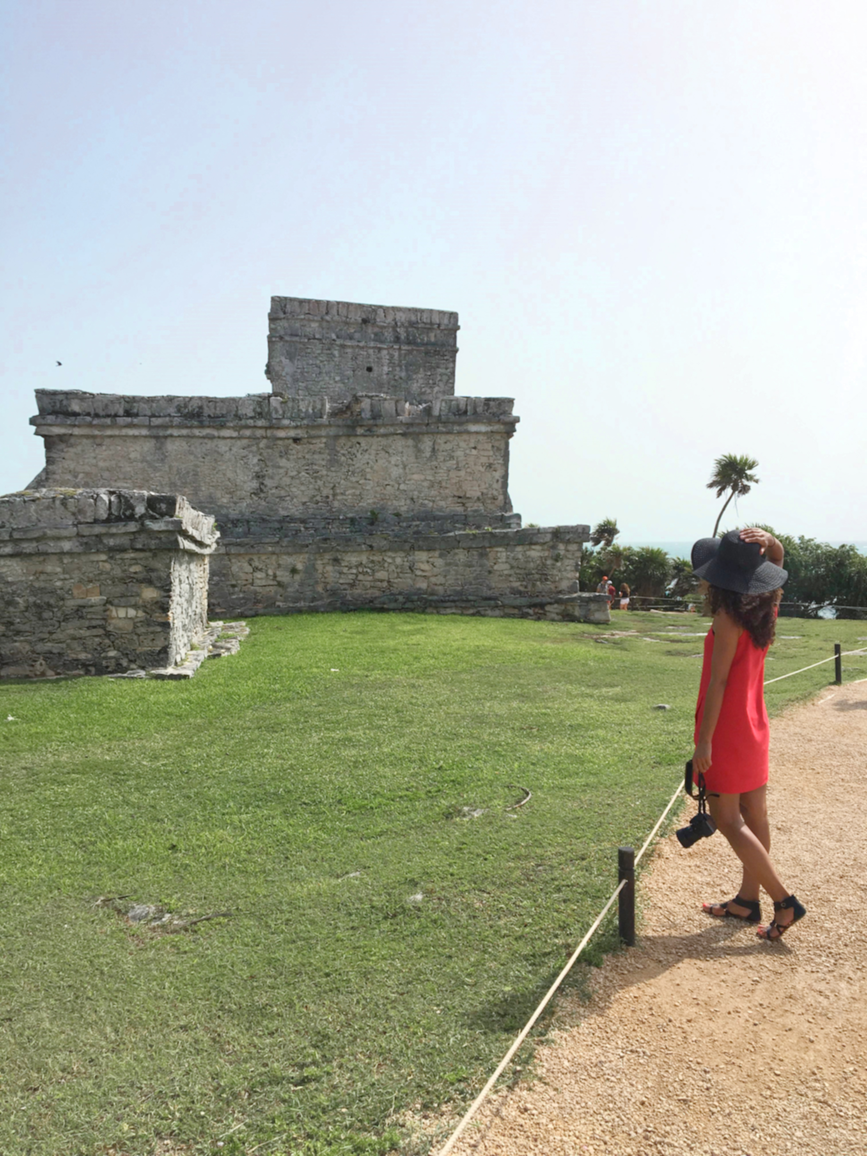Standing with a camera at the Tulum Ruins in Mexico