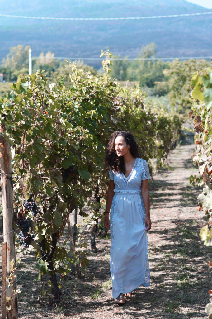 Wearing a lavender lace Rent the Runway dress at a vineyard in Italy