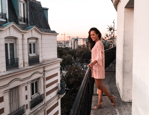 On a balcony in Paris wearing Rent the Runway